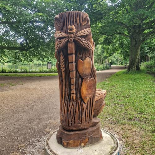Wooden dragonfly and tulips, in woods